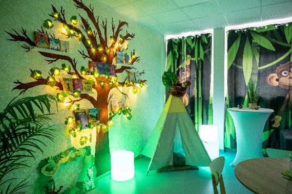 Raum, der wie ein Dschungel eingerichtet ist mit einm Zelt